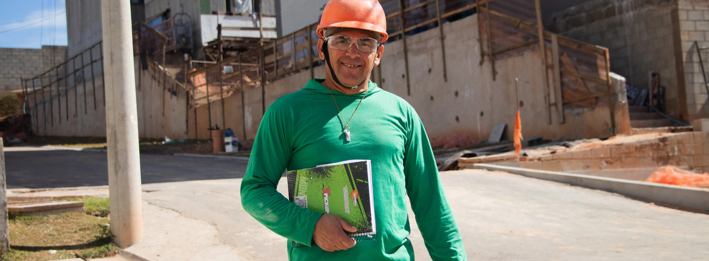 Franscisco da Silva Costa sorrindo vestido  de blusa verde, capacete laranja e óculos de  proteção