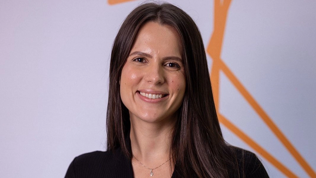 Carolline Pelizzaro, engenheira MRV de blusa e calça preta sorrindo